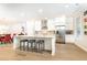 Open kitchen with an island, seating, stainless appliances, white cabinetry, and hardwood floors at 555 Letchas Ln, Alpharetta, GA 30009