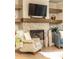 Cozy living room with fireplace, wood mantel, and floating shelves for decor at 555 Letchas Ln, Alpharetta, GA 30009