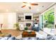 Bright living room with fireplace, floating shelves, and sliding glass doors to outdoor patio space at 555 Letchas Ln, Alpharetta, GA 30009