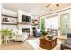 Inviting living room with fireplace, mantel, floating shelves, and sliding glass doors to outdoor patio at 555 Letchas Ln, Alpharetta, GA 30009