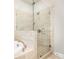 Modern shower showcasing sleek glass doors and tile surround, enhancing the luxurious bathroom design at 555 Letchas Ln, Alpharetta, GA 30009