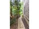 Landscaped side yard featuring a stone paver walkway, mature trees and mulch at 555 Letchas Ln, Alpharetta, GA 30009