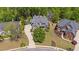 Expansive aerial view of the property showing the house, driveway, mature landscaping, and neighborhood at 5885 Wild Azalea Cv, Sugar Hill, GA 30518