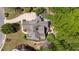 Aerial view showcasing the home's sprawling roofline, landscaped backyard, and outdoor patio with seating at 5885 Wild Azalea Cv, Sugar Hill, GA 30518