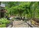 Beautifully landscaped backyard featuring a stone pathway, mature trees, and outdoor seating areas at 5885 Wild Azalea Cv, Sugar Hill, GA 30518