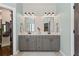 Elegant bathroom featuring a double vanity, modern lighting, and a walk-in closet at 5885 Wild Azalea Cv, Sugar Hill, GA 30518