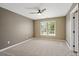 A bright, neutral bedroom features carpet, a ceiling fan, and a large window at 5885 Wild Azalea Cv, Sugar Hill, GA 30518