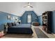 Comfortable bedroom with a sloped ceiling, and accent wall with modern decor at 5885 Wild Azalea Cv, Sugar Hill, GA 30518