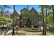 Back of house with multiple windows, a deck, patio, and landscaped yard with greenery, trees, and seating at 5885 Wild Azalea Cv, Sugar Hill, GA 30518