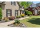 Beautiful home exterior featuring a stone facade, well-manicured landscaping, and a curved walkway leading to the entrance at 5885 Wild Azalea Cv, Sugar Hill, GA 30518