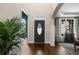 Elegant foyer featuring hardwood floors, high ceilings, and a view into the dining area, bathed in natural light at 5885 Wild Azalea Cv, Sugar Hill, GA 30518