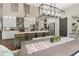 Open-concept kitchen features stainless appliances, pendant lighting, a large island, and adjacent dining area at 5885 Wild Azalea Cv, Sugar Hill, GA 30518