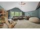 Spacious living room with comfortable seating, bookshelf and serene view to nature at 5885 Wild Azalea Cv, Sugar Hill, GA 30518