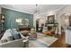 Spacious living room boasts decorative green paneling, hardwood floors, and cozy seating around an area rug at 5885 Wild Azalea Cv, Sugar Hill, GA 30518
