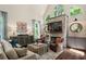 Inviting living room featuring a stone fireplace, large windows, hardwood floors, and comfortable seating at 5885 Wild Azalea Cv, Sugar Hill, GA 30518