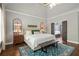 Spacious primary bedroom with a large bed and a door leading to an en suite bathroom at 5885 Wild Azalea Cv, Sugar Hill, GA 30518