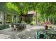 Expansive outdoor patio with dining and lounge areas, surrounded by lush greenery and mature trees at 5885 Wild Azalea Cv, Sugar Hill, GA 30518