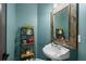 Stylish powder room features a pedestal sink, decorative mirror, and vibrant blue walls at 5885 Wild Azalea Cv, Sugar Hill, GA 30518