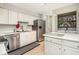 Functional kitchen with stainless steel appliances and white cabinetry with in-unit laundry at 11 Forrest Pl, Atlanta, GA 30328