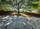 Large backyard with mature tree, a wood fence, and concrete slab, perfect for Gathering gatherings at 1417 Wind Chime Ct, Lawrenceville, GA 30045