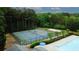 Aerial view of community tennis courts, pool, and surrounding trees at 1425 Bridle Path Dr, Lawrenceville, GA 30045