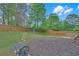Landscaped backyard with a wooden fence, garden bed, and a seating area at 1425 Bridle Path Dr, Lawrenceville, GA 30045