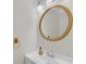 Simple half bath with a round gold-framed mirror and a white vanity, offering practicality and style at 1425 Bridle Path Dr, Lawrenceville, GA 30045
