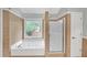 Bathroom with a soaking tub, glass shower and neutral-toned tile at 1425 Bridle Path Dr, Lawrenceville, GA 30045