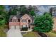Charming two-story brick home with manicured lawn and driveway, framed by lush trees in a neighborhood setting at 1425 Bridle Path Dr, Lawrenceville, GA 30045