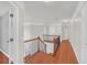 Upstairs hallway with hardwood floors, doors, and neutral paint; bright and inviting transition space at 1425 Bridle Path Dr, Lawrenceville, GA 30045