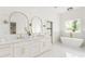 Luxurious bathroom with double vanity, gold fixtures, soaking tub, and marble flooring at 156 Martha Ne Ave, Atlanta, GA 30317