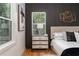 Comfortable bedroom with hardwood floors, a nightstand, and a large window at 156 Martha Ne Ave, Atlanta, GA 30317