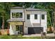 Modern two-story home featuring white siding, black trim, a covered entry, and a convenient attached garage at 156 Martha Ne Ave, Atlanta, GA 30317