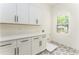 Laundry room features built in cabinets, modern hardware, and a window overlooking the yard at 156 Martha Ne Ave, Atlanta, GA 30317