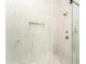 Walk-in shower features marble tile surround, a built-in niche, and premium bronze hardware at 156 Martha Ne Ave, Atlanta, GA 30317