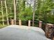 A large concrete deck with brick columns and iron railing overlooks lush green backyard and mature trees at 2429 Sherbrooke Ne Ct, Atlanta, GA 30345
