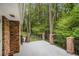 A large concrete deck with brick columns and iron railing overlooks lush green backyard and mature trees at 2429 Sherbrooke Ne Ct, Atlanta, GA 30345