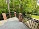 A large concrete deck with brick columns and iron railing overlooks lush green backyard and mature trees at 2429 Sherbrooke Ne Ct, Atlanta, GA 30345