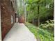 Brick home featuring a concrete patio next to a lush green backyard with mature trees and shade at 2429 Sherbrooke Ne Ct, Atlanta, GA 30345