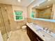 Modern bathroom with double sinks, tiled shower and walls, and natural light at 2429 Sherbrooke Ne Ct, Atlanta, GA 30345