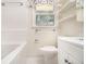 Well-lit bathroom with tile, tub, floating shelves, and updated sink at 2429 Sherbrooke Ne Ct, Atlanta, GA 30345