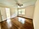 Bedroom features hardwood floors, a ceiling fan, and natural light from the large window at 2429 Sherbrooke Ne Ct, Atlanta, GA 30345