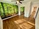 Bedroom features hardwood floors, a ceiling fan, and a scenic forest mural accent wall at 2429 Sherbrooke Ne Ct, Atlanta, GA 30345