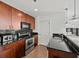 Stylish kitchen with dark wood cabinets, black countertops and backsplash, and stainless appliances at 361 17Th Nw St # 1222, Atlanta, GA 30363