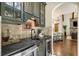 Stylish wet bar with a dark countertop, wine fridge, and custom tile work at 5625 Buckleigh Pointe, Suwanee, GA 30024