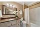 Bathroom with neutral color scheme, elegant vanity with marble countertop, mirror, and a shower with a white curtain at 5625 Buckleigh Pointe, Suwanee, GA 30024