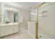 Bright bathroom featuring a vanity with a marble countertop, a mirror, and a glass-enclosed shower and bright lighting at 5625 Buckleigh Pointe, Suwanee, GA 30024