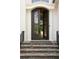 Elegant iron front door with stone steps and decorative columns at 5625 Buckleigh Pointe, Suwanee, GA 30024