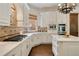 Well-appointed kitchen with custom cabinetry, stone backsplash, and luxury appliances at 5625 Buckleigh Pointe, Suwanee, GA 30024