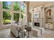 Bright living room featuring a fireplace, built-ins, and large windows overlooking a lush yard at 5625 Buckleigh Pointe, Suwanee, GA 30024